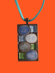 pendentif rectangulaire, support couleur cuivre, composé de galets japonais et de carrés de verre, bleu griset vert, coron suédine bleu